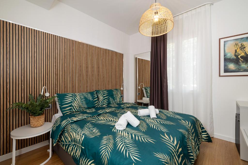 une chambre avec un lit avec une couette verte dans l'établissement Hotel La Pergola di Venezia, sur le Lido de Venise