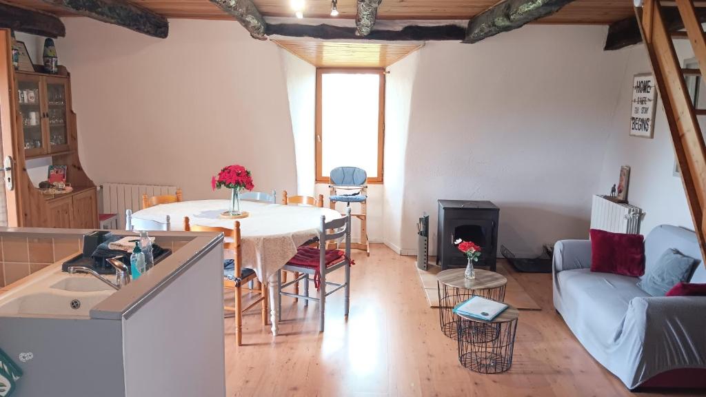 une cuisine et un salon avec une table et un canapé dans l'établissement Le grand gîte, à Saint-Beauzély