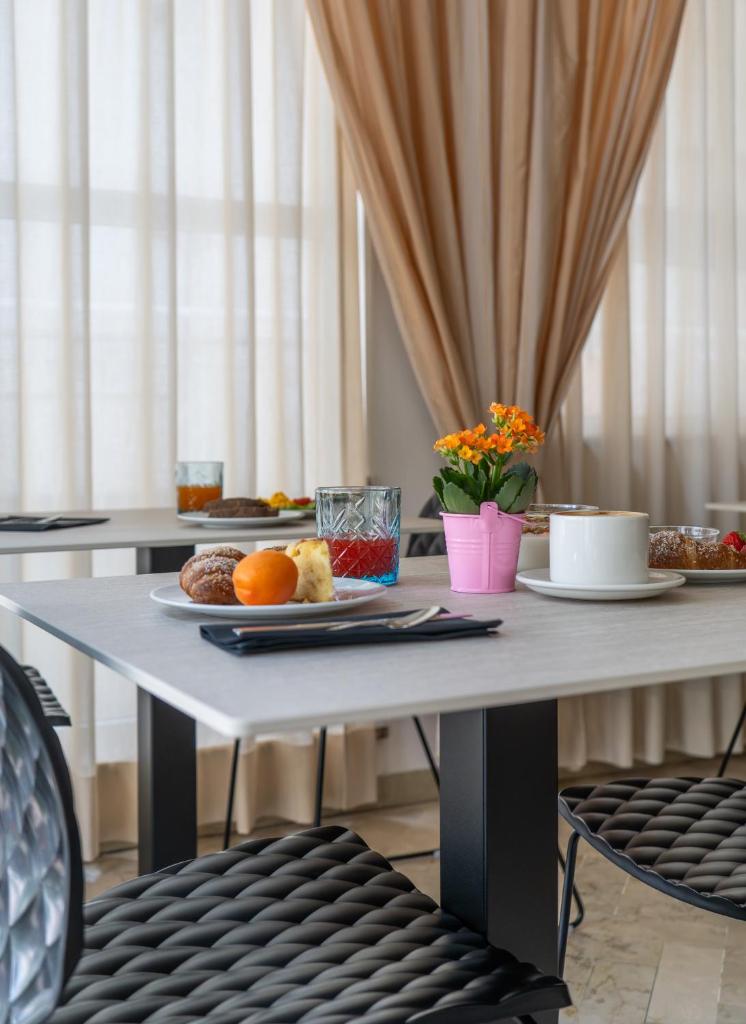 une table avec des assiettes de nourriture dessus dans l'établissement Mon Hotel, à Misano Adriatico