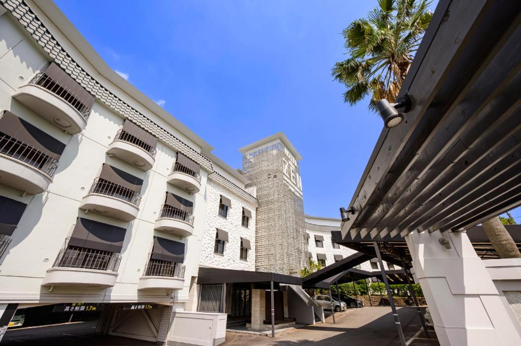 un bâtiment avec un palmier devant dans l'établissement Hotel Zen Rikyu Yokohama Hazawa, à Yokohama