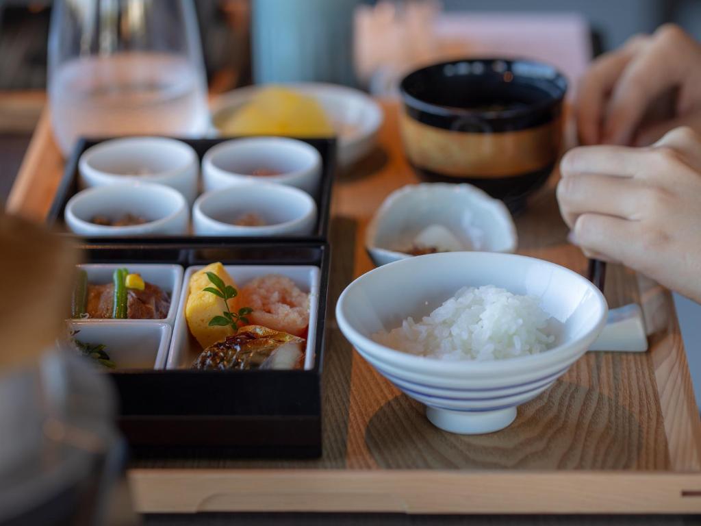 une table avec des sushis et un bol de riz dans l'établissement ONCRI-Karatsu おんくり唐津, à Karatsu