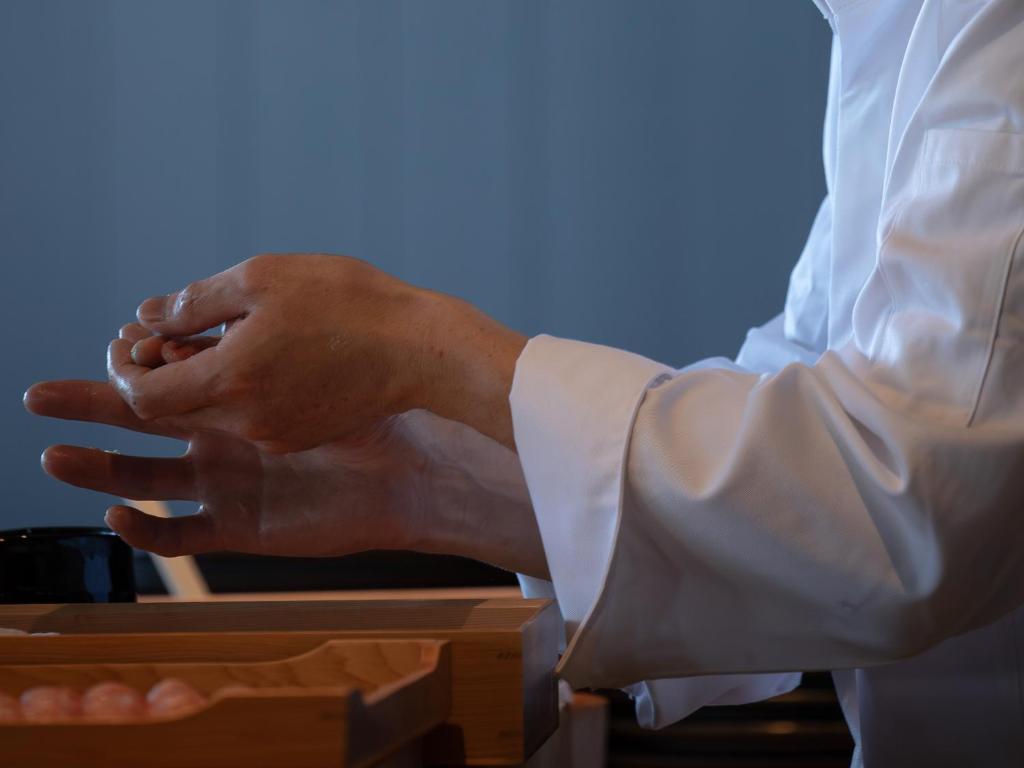 un homme en chemise blanche se tient les mains dans l'établissement ONCRI-Karatsu おんくり唐津, à Karatsu