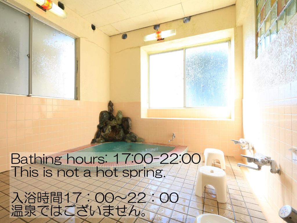 une salle de bain avec une baignoire, des toilettes et un lavabo dans l'établissement Sunrise Meiji-ya, à Nozawa Onsen