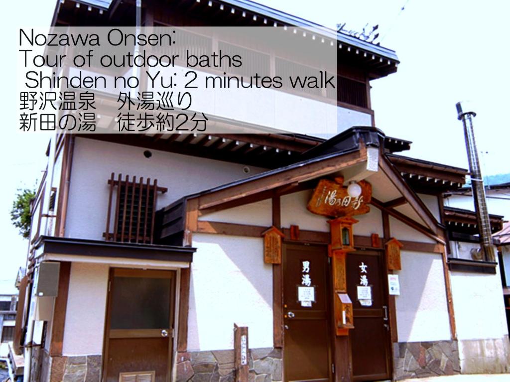 un bâtiment avec un panneau indiquant nova oxygen quatre des bains extérieurs similaires à dans l'établissement Sunrise Meiji-ya, à Nozawa Onsen