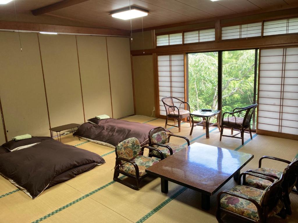 une chambre avec deux lits, une table et des chaises dans l'établissement HOTEL LT Kitchen Yugawara, à Yugawara 37 autres photos