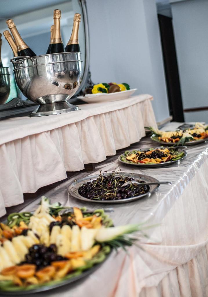 - un buffet avec des assiettes de nourriture et des bouteilles de champagne dans l'établissement Hotel Carillon, à Bellaria-Igea Marina 80 autres photos