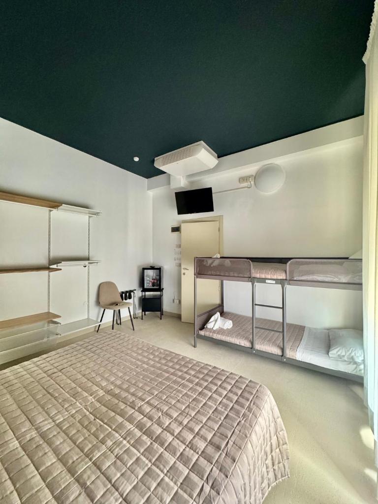 une chambre avec deux lits superposés et un bureau dans l'établissement Hotel Dinkli, à Rimini