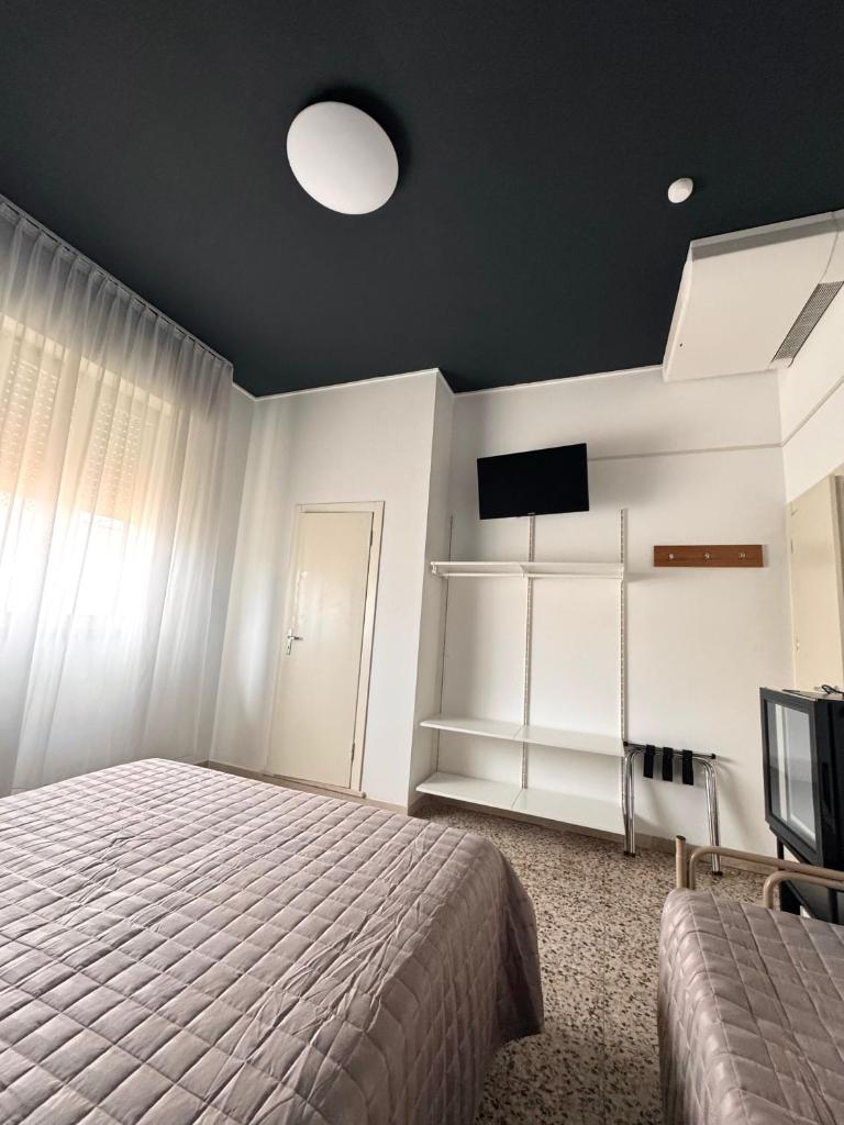 une chambre avec un lit et une télévision à écran plat dans l'établissement Hotel Dinkli, à Rimini