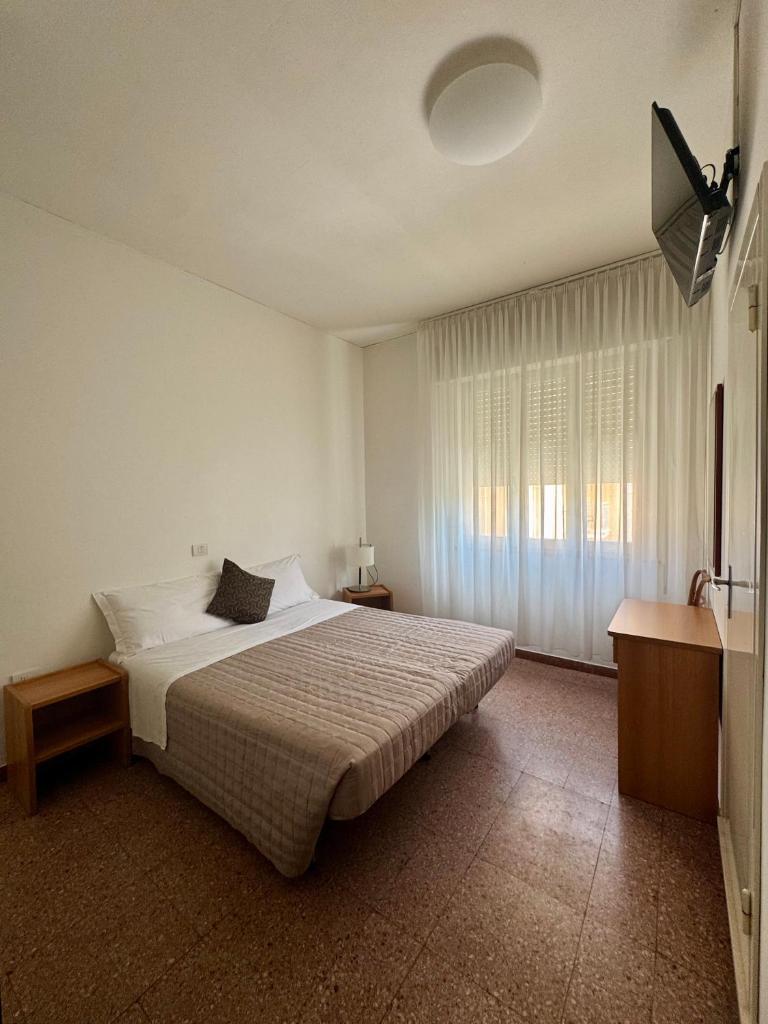 une chambre avec un grand lit et une fenêtre dans l'établissement Hotel Dinkli, à Rimini