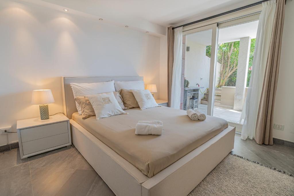 une chambre blanche avec un grand lit et une fenêtre dans l'établissement Villa La Gioia, à Terra Mala