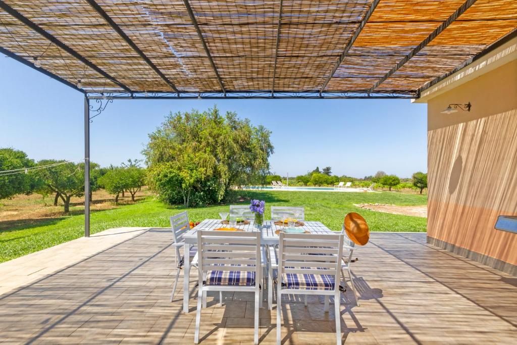 un patio avec une table et des chaises sur une terrasse dans l'établissement La Rossi with pool Gallipoli 4, à Gallipoli