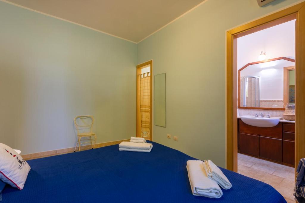 - une chambre avec un lit bleu et un lavabo dans l'établissement Country House La Rossi with pool Gallipoli 7, à Gallipoli