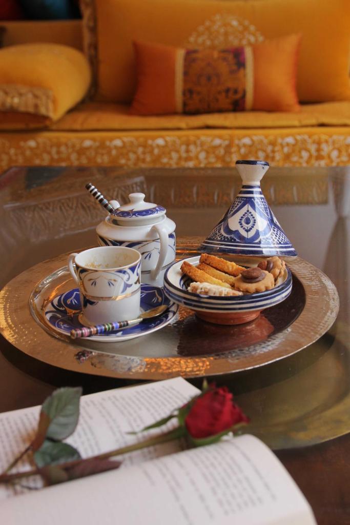 - une table avec une assiette de nourriture et un service à thé dans l'établissement Riad Passali, à Marrakech