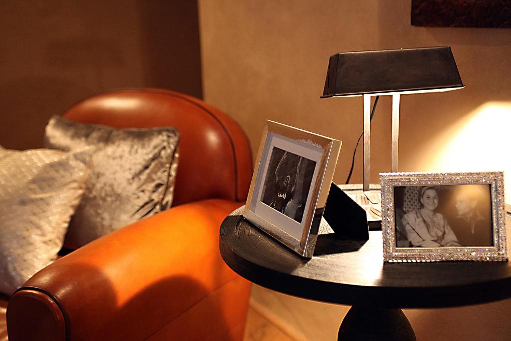 une table avec deux photos, une chaise et une lampe dans l'établissement L'Alcazar, à Rabat
