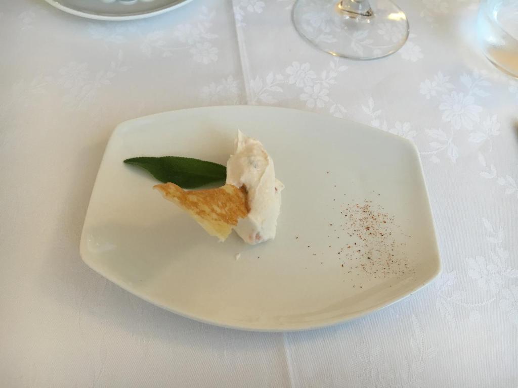 une plaque blanche avec un morceau de nourriture sur une table dans l'établissement Hotel Mar Del Plata, à Grado