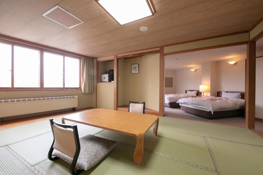 - une chambre avec une table et un lit dans l'établissement Hotel Higashidate, à Yamanouchi