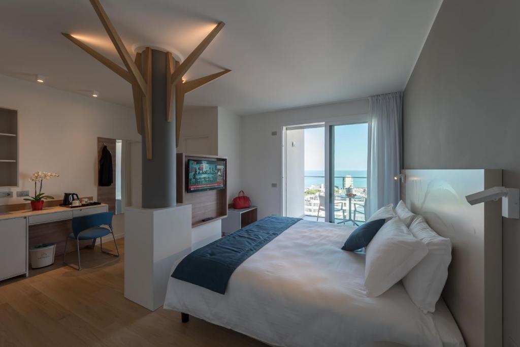 une chambre avec un lit, un bureau et une fenêtre dans l'établissement Hesperia Hotel & Residence, à Lido di Jesolo