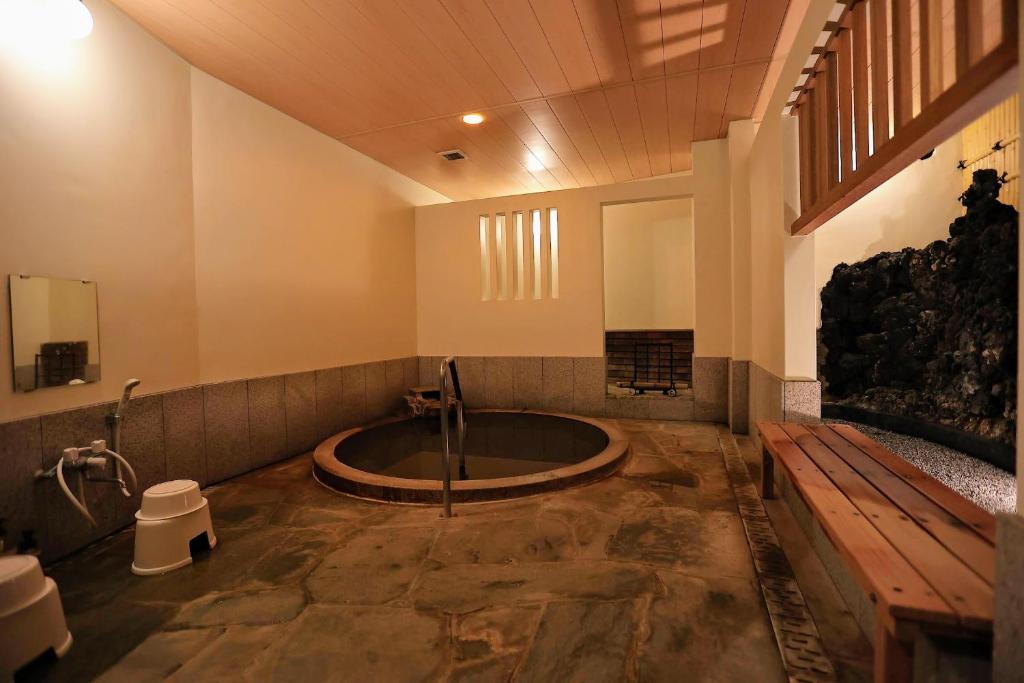 une salle de bain avec une baignoire au milieu d'une pièce dans l'établissement 熱海温泉 法悦 旅館, à Atami