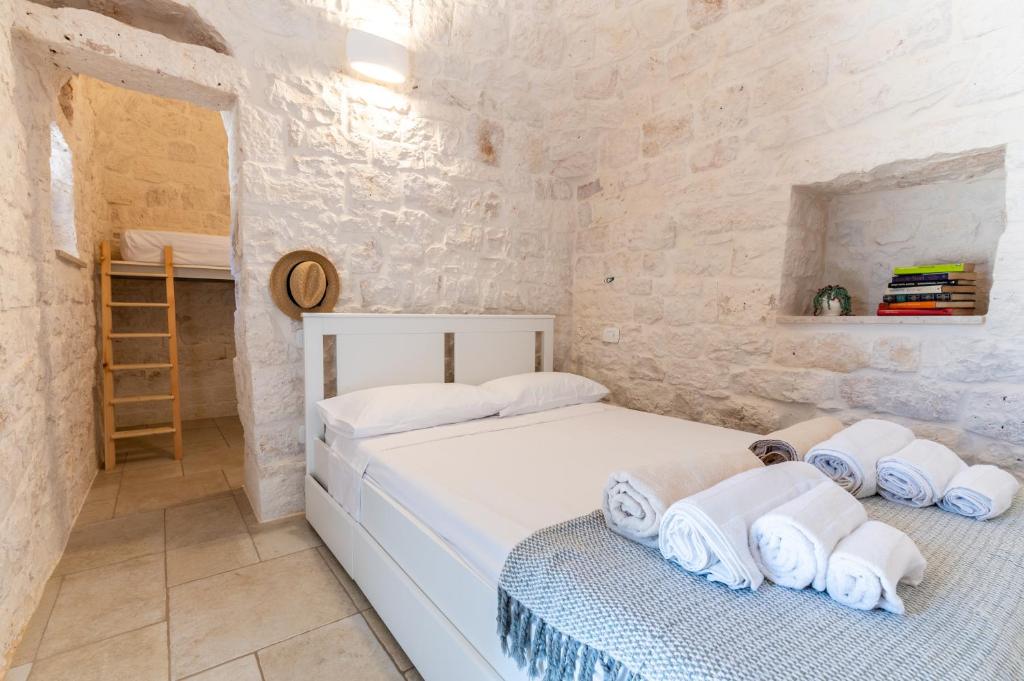 - une chambre avec 2 lits dans un mur en pierre dans l'établissement Trulli Cocol, à Cocolicchio