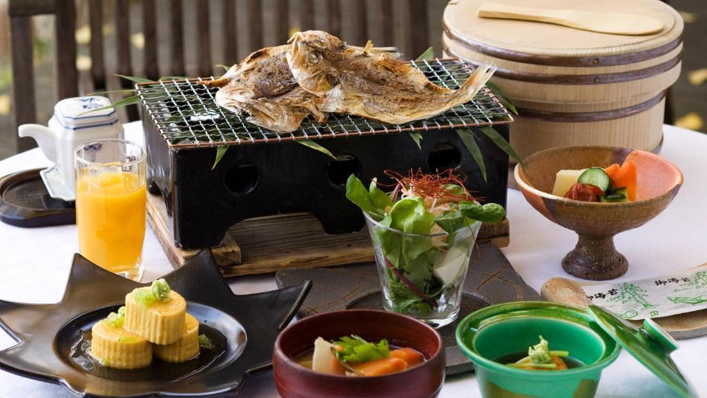 une table remplie de nourriture et d'une assiette de nourriture dans l'établissement Yumenoian Yuyake Koyake, à Himeji