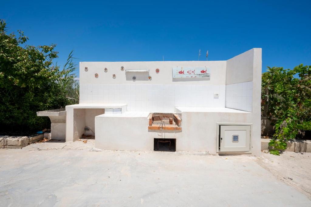 un bâtiment blanc avec une cheminée au milieu dans l'établissement Villa Marzamemi with pool, à Marzamemi