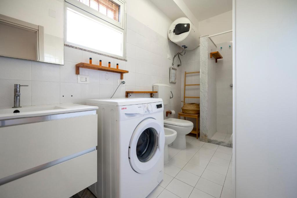 une salle de bain avec machine à laver et toilettes dans l'établissement Villa Marzamemi with pool, à Marzamemi