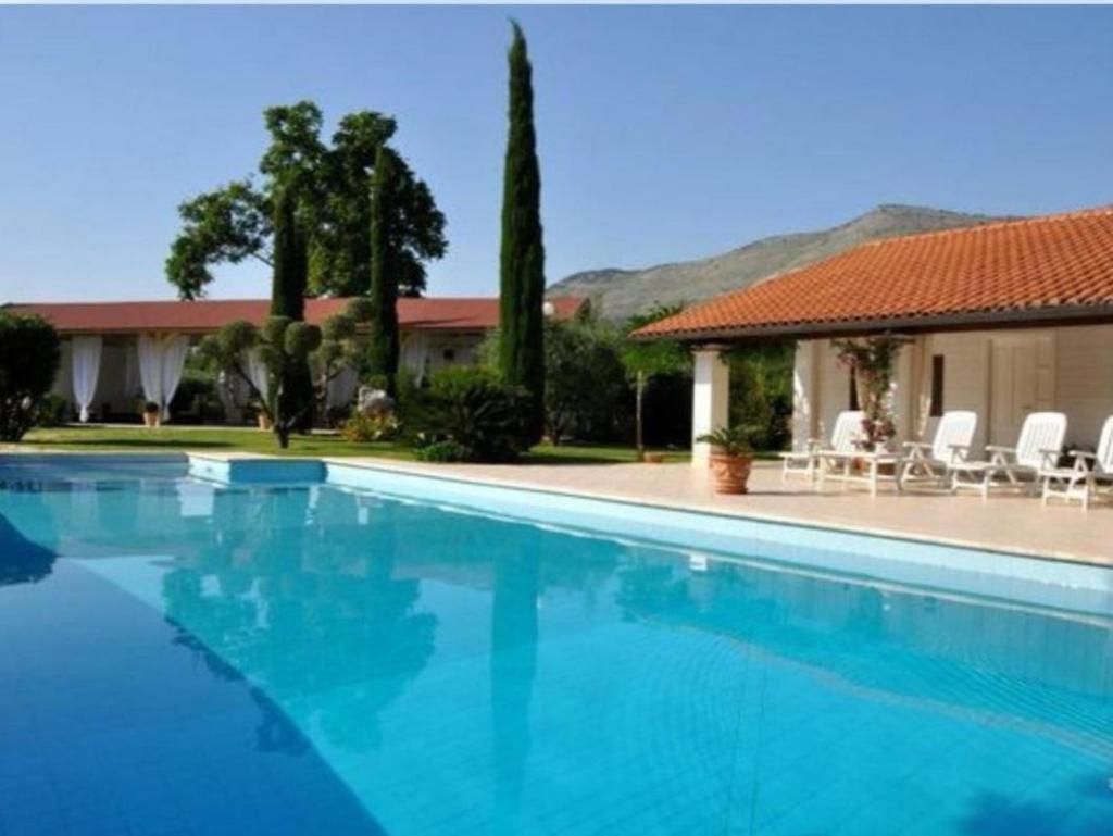 une piscine bleue avec des chaises et une maison dans l'établissement Villetta BLUE GARDEN, à Sonnino