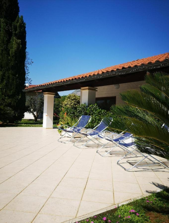 un groupe de chaises assises sur une terrasse dans l'établissement Villetta BLUE GARDEN, à Sonnino