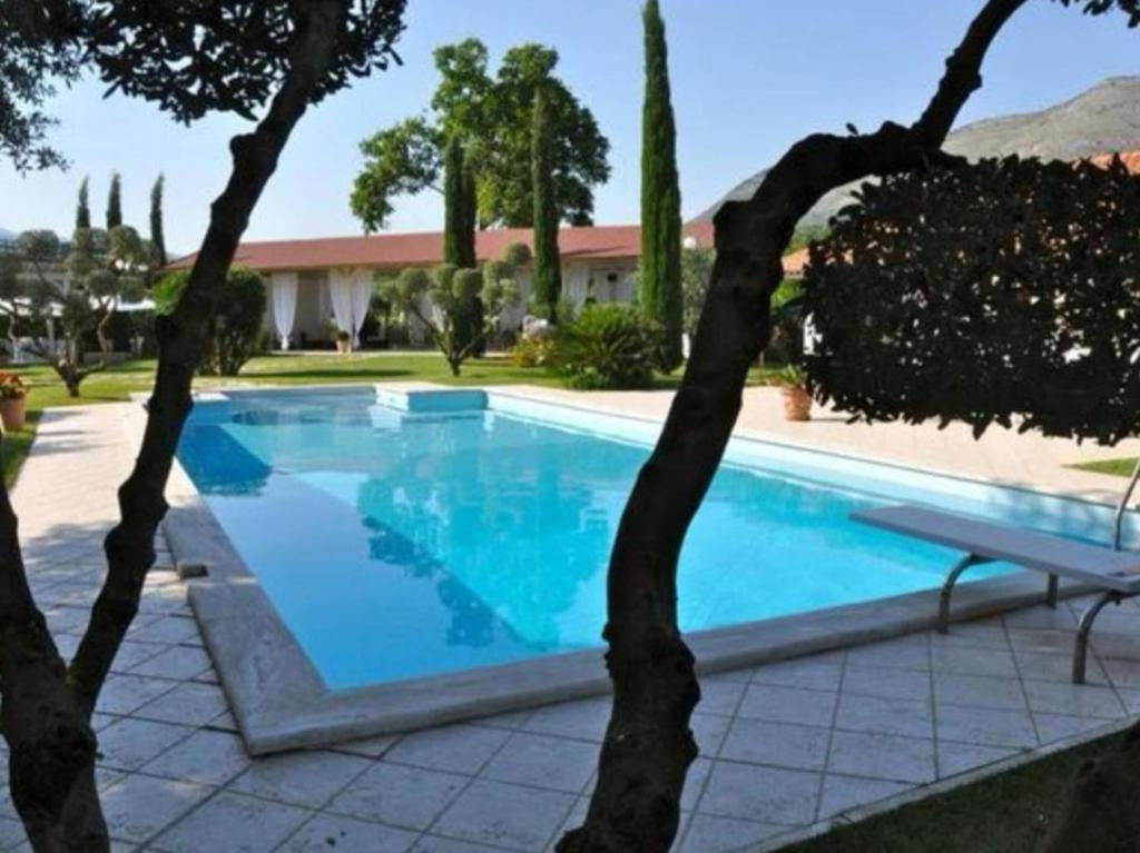 - une piscine avec des arbres devant une maison dans l'établissement Villetta BLUE GARDEN, à Sonnino 34 autres photos