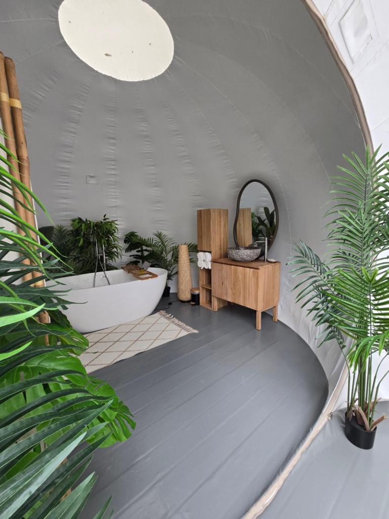 Cette chambre est dotée de plantes en pot et d'une baignoire. dans l'établissement La bulle perchée de Chantilly, à Gouvieux