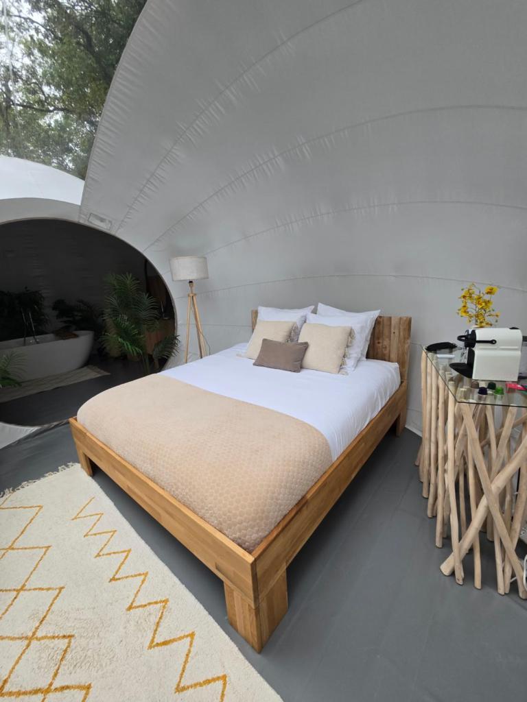 - une chambre avec un grand lit dans une tente dans l'établissement La bulle perchée de Chantilly, à Gouvieux