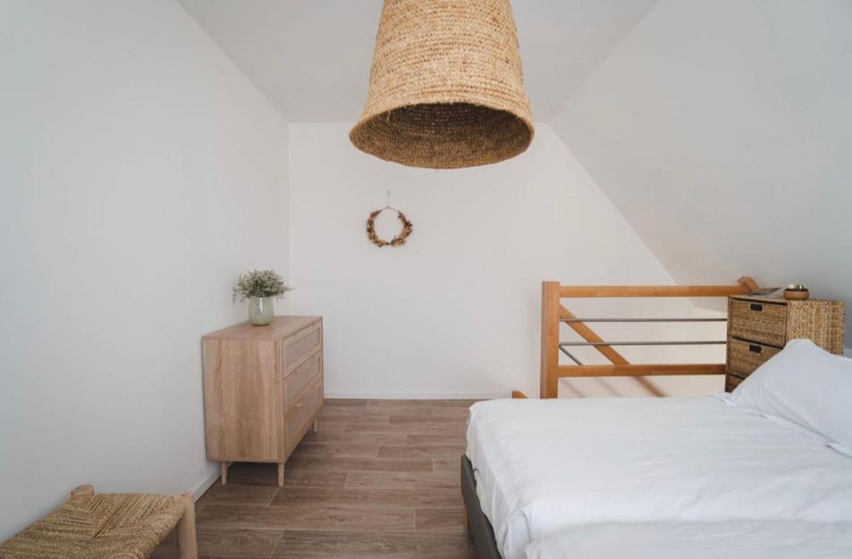 - une chambre avec un lit, une chaise et un lustre dans l'établissement Le Clos Bleu - Gite Rural, à Schillersdorf 15 autres photos