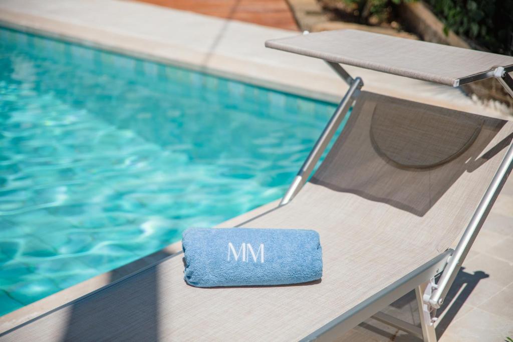 une piscine avec un panneau mn sur une chaise à côté d'une piscine dans l'établissement Musa Maris - Villa panoramica con piscina, à Conversano