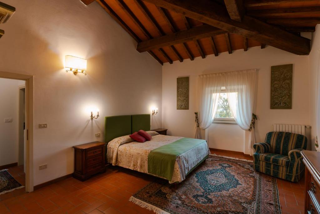 une chambre avec un lit, une fenêtre et une chaise dans l'établissement Villa Casale Chiesina, à Bibbiena