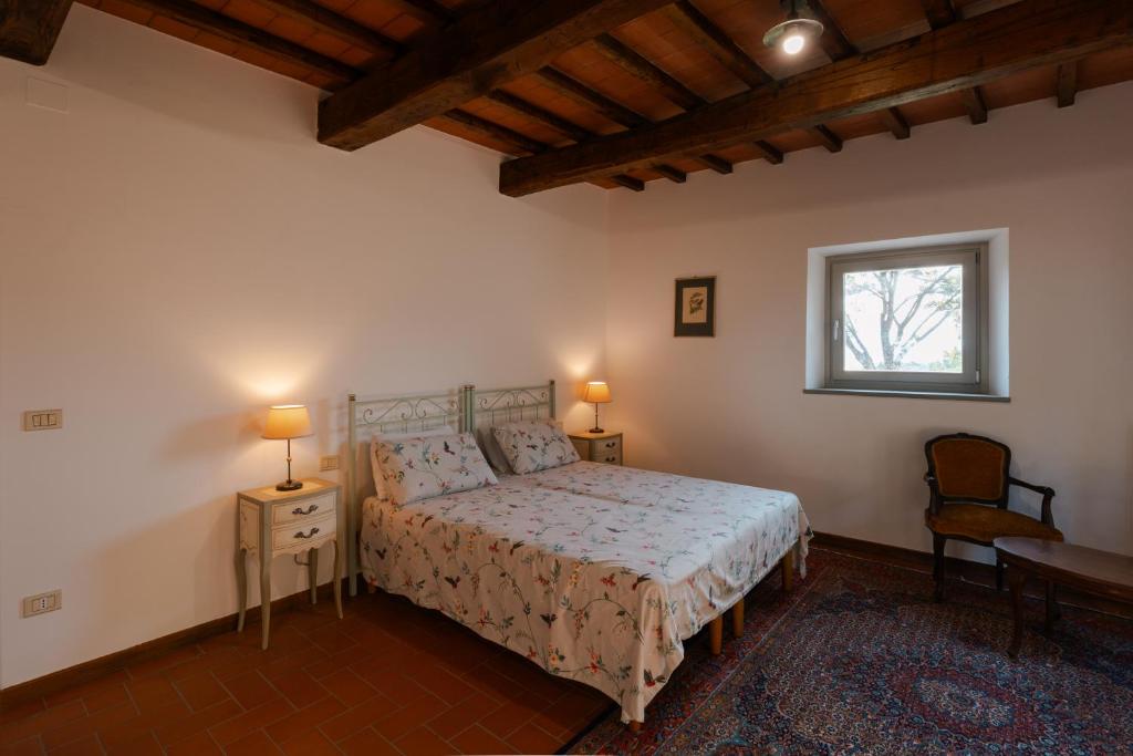 une chambre avec un lit et deux tables et une fenêtre dans l'établissement Villa Casale Chiesina, à Bibbiena
