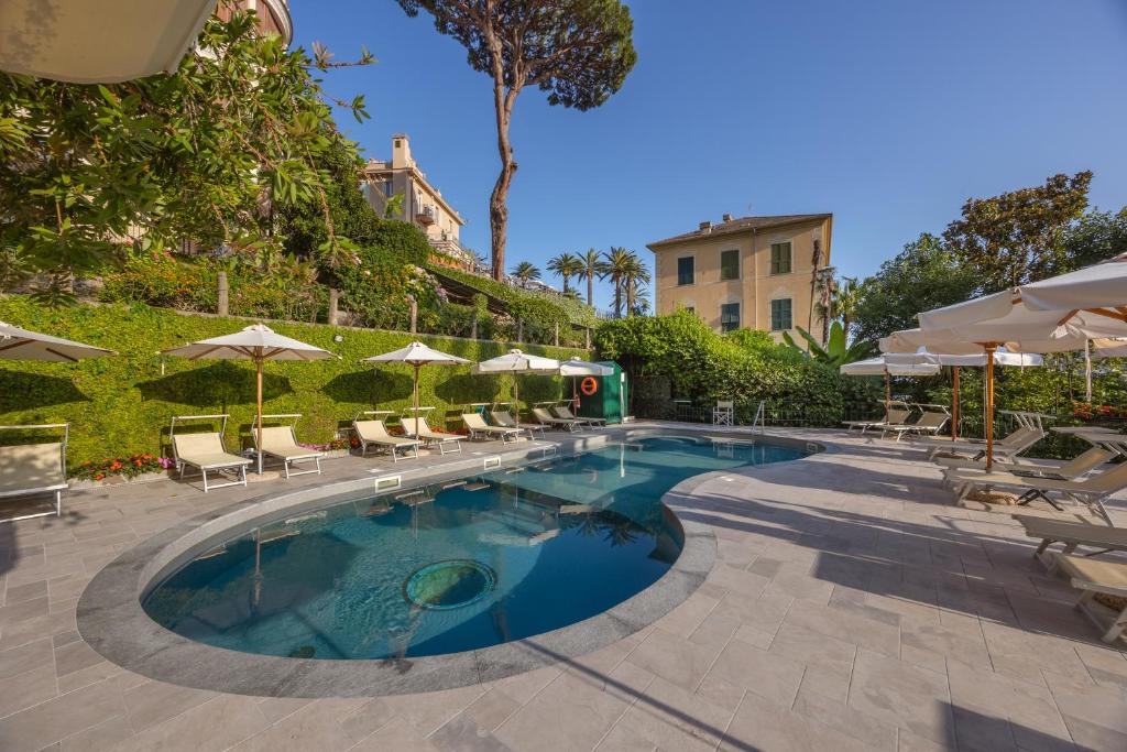 une piscine avec chaises longues et parasols dans l'établissement Hotel Metropole, à Santa Margherita Ligure