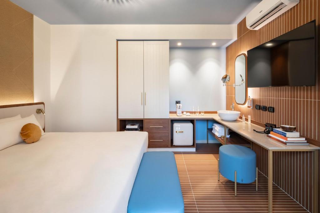 une chambre avec un grand lit et une salle de bain dans l'établissement Tuscany Hotel Alle Dune, à Marina di Castagneto Carducci