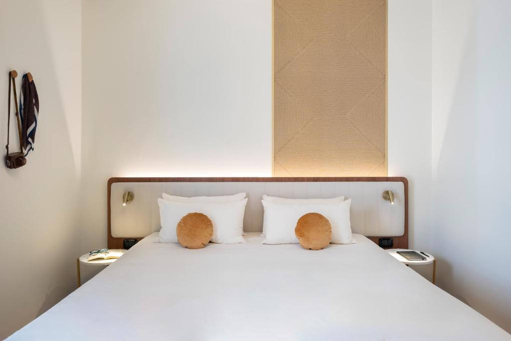 un lit blanc avec deux animaux en peluche dessus dans l'établissement Tuscany Hotel Alle Dune, à Marina di Castagneto Carducci