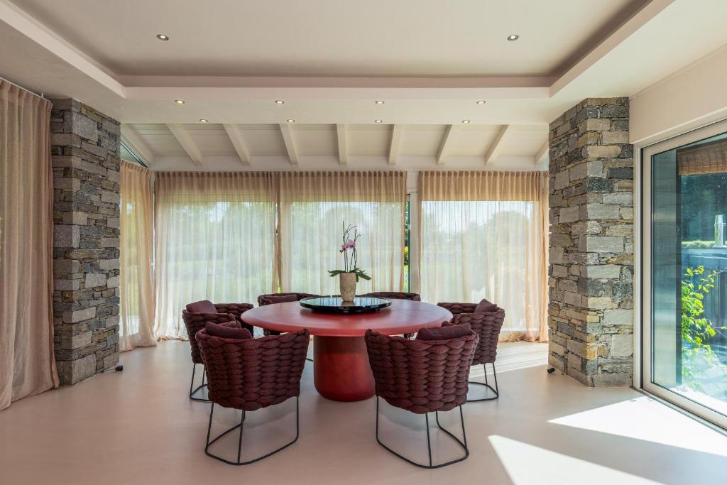 une salle à manger avec une table et des chaises rouges dans l'établissement Luxury Golf Villa, à Bogogno