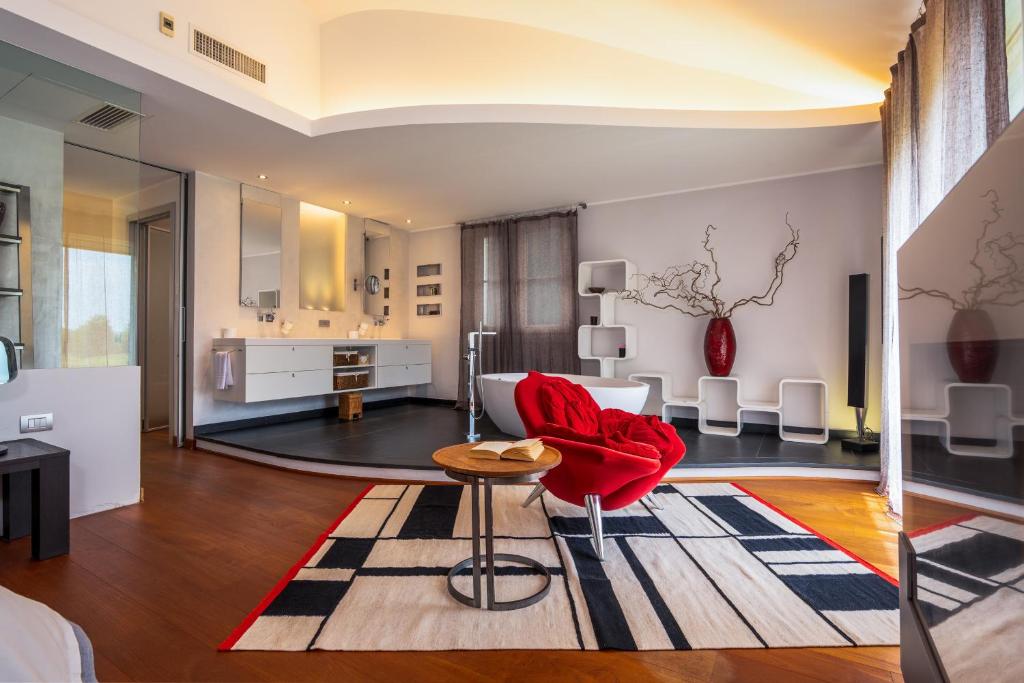 un salon avec une chaise rouge et une table dans l'établissement Luxury Golf Villa, à Bogogno