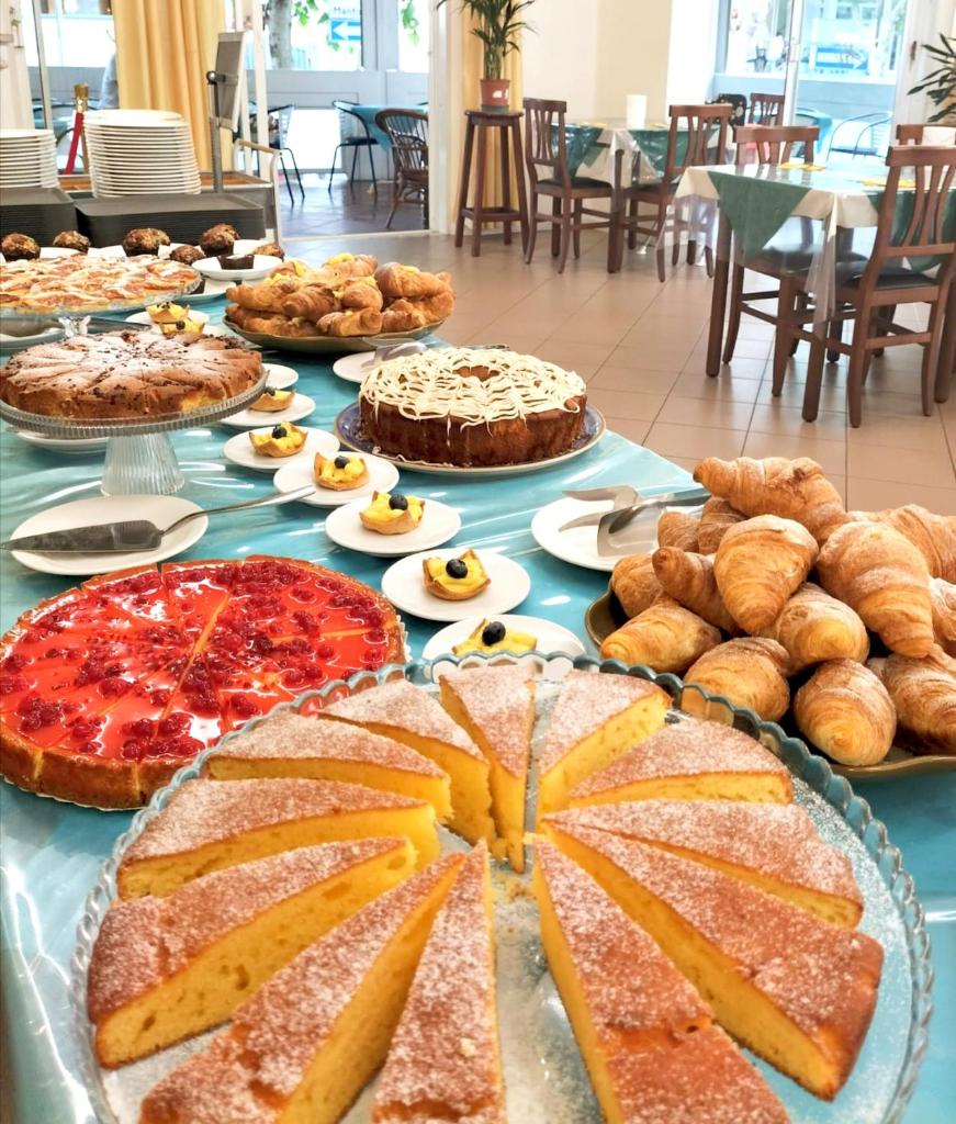une table avec de nombreux types différents de tartes et de pâtisseries dans l'établissement Hotel Cà Vanni, à Rimini