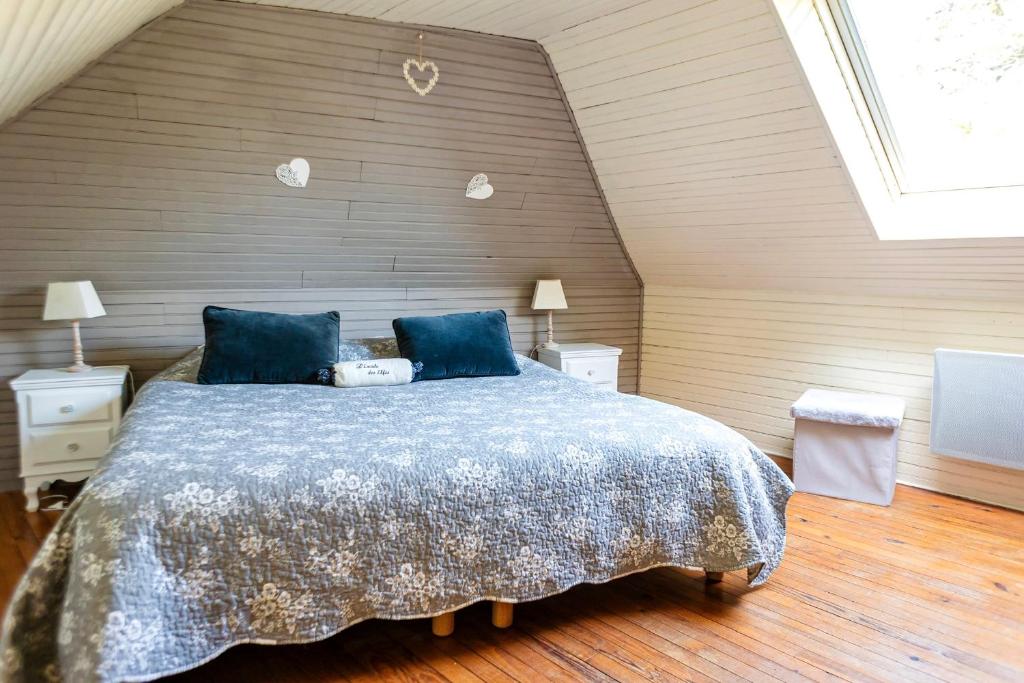 une chambre avec un grand lit avec des oreillers bleus dans l'établissement Gîte Bihan 4P piscine ou jacuzzi, à Saint-Évarzec 35 autres photos
