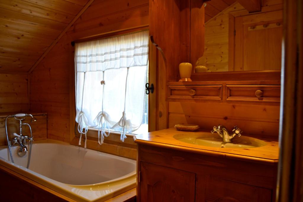 une salle de bain avec une baignoire et un lavabo dans l'établissement Chalet le Lagopède, à La Joue du Loup
