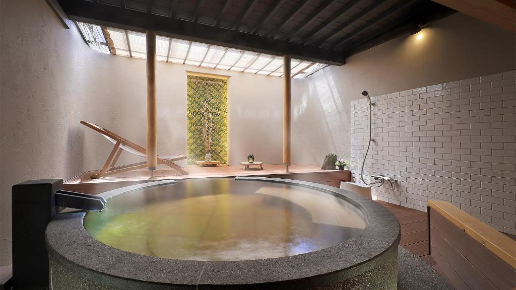 une grande baignoire dans une salle de bain avec une fenêtre dans l'établissement Hotel Sunshine Kinugawa, à Nikkō