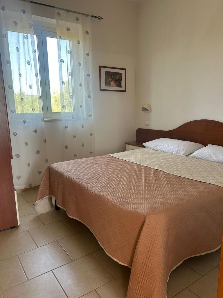 une chambre avec un grand lit et deux fenêtres dans l'établissement Appartamenti Vacanze Minervino, à Vieste 194 autres photos