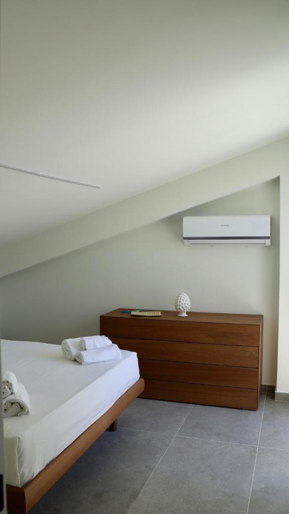 une chambre avec un lit et une commode en bois dans l'établissement Villa Zagara modern villa with pool, à Lascari