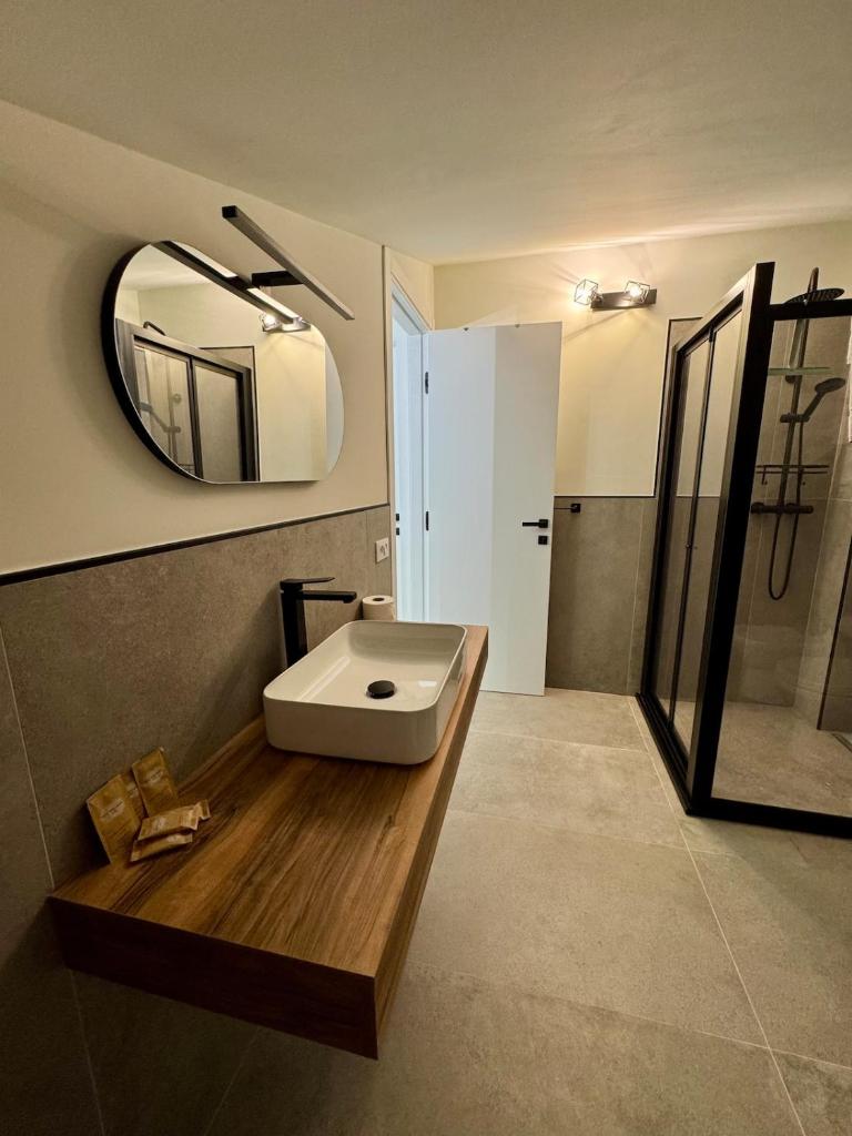 une salle de bain avec un lavabo blanc et un miroir dans l'établissement Villa Zagara modern villa with pool, à Lascari