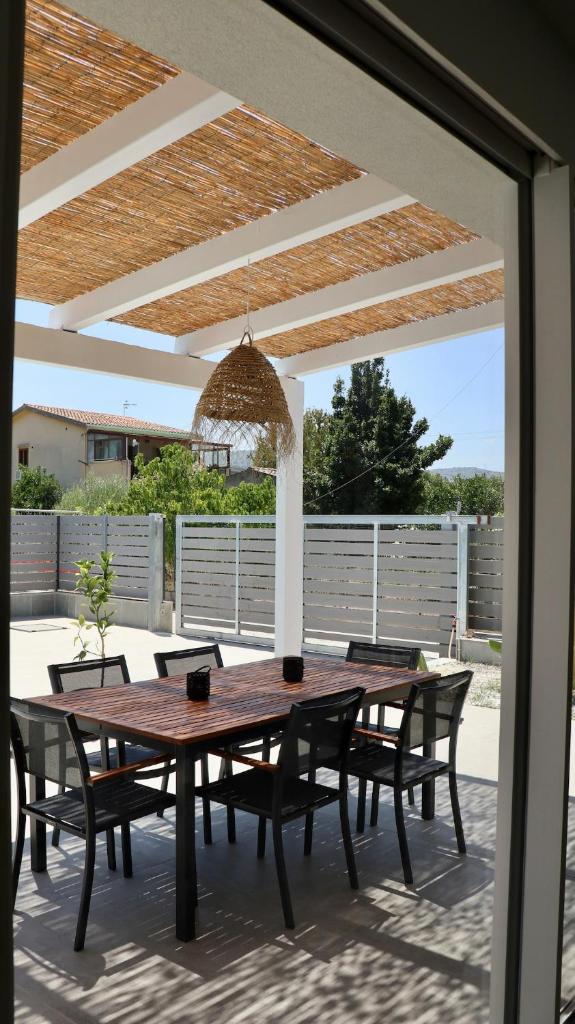une table et des chaises en bois sur une terrasse dans l'établissement Villa Zagara modern villa with pool, à Lascari