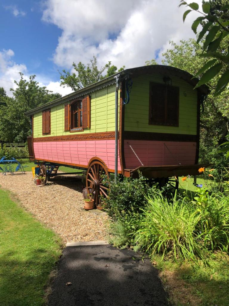une remorque colorée est garée dans une cour dans l'établissement ROULOTTE CAPUCINE, à Ablon