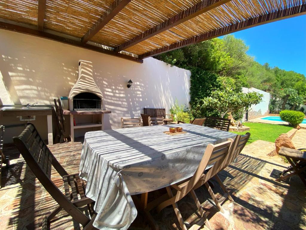 d'une terrasse avec une table et un four à pizza. dans l'établissement Villa Mariposa exclusive private pool, à Budoni